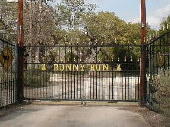 Bunny Run iron entrance gate with a rabbit silhouette sign overhead, West Lake Hills area, Texas